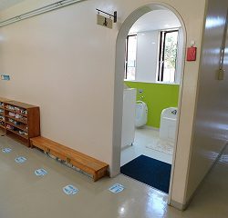園内環境として、トイレの中で密にならないように廊下で並ぶ位置を足型を置いて示しました